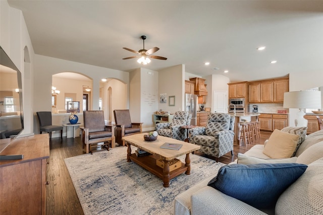 living area with wood finished floors, recessed lighting, a ceiling fan, and arched walkways