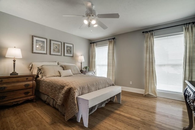 bedroom featuring ceiling fan, baseboards, and wood finished floors