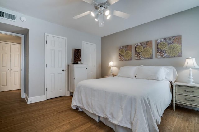bedroom featuring wood finished floors, ceiling fan, baseboards, and visible vents