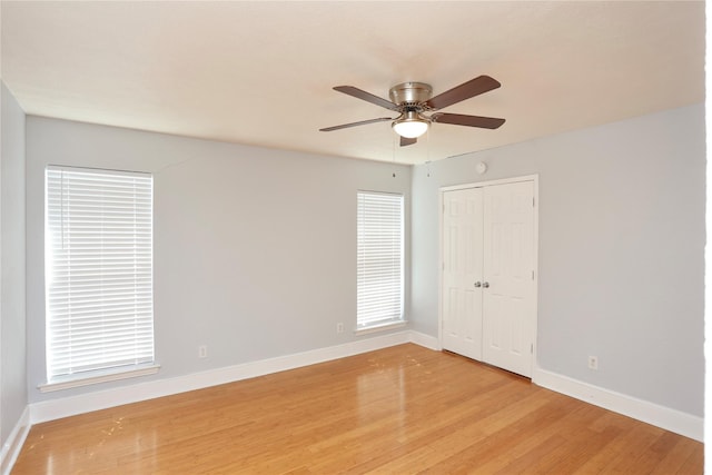 empty room with baseboards, light wood-style flooring, and a ceiling fan