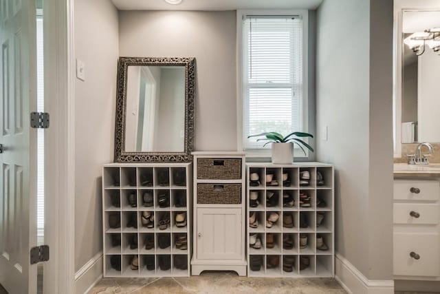 bar featuring baseboards and a sink