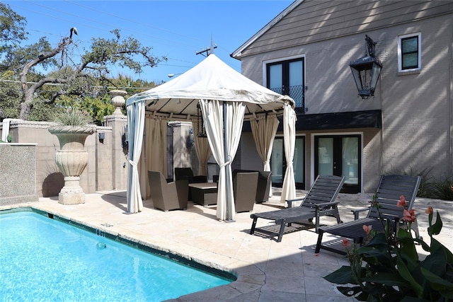 pool with a patio area, an outdoor living space, french doors, and fence