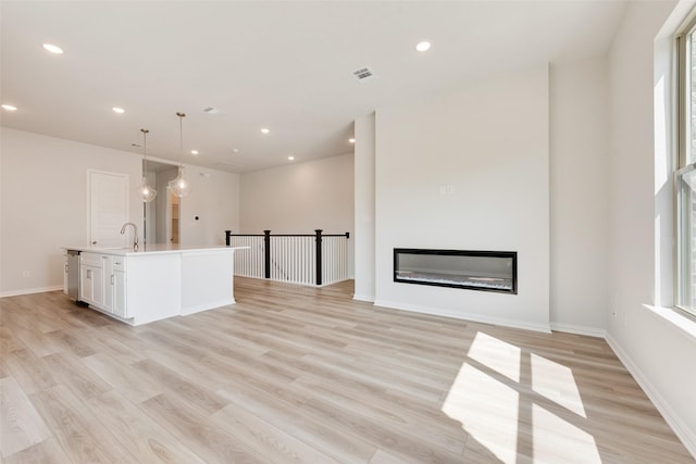 4301 Ruth Rd, North Richland Hills, TX 76180 - unfurnished living room with recessed lighting, a sink, and light wood-style floors
