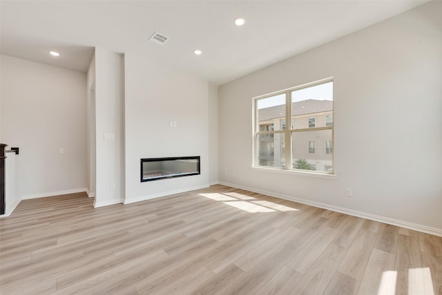 4301 Ruth Rd, North Richland Hills, TX 76180 - unfurnished living room featuring a glass covered fireplace, light wood-style floors, baseboards, and visible vents