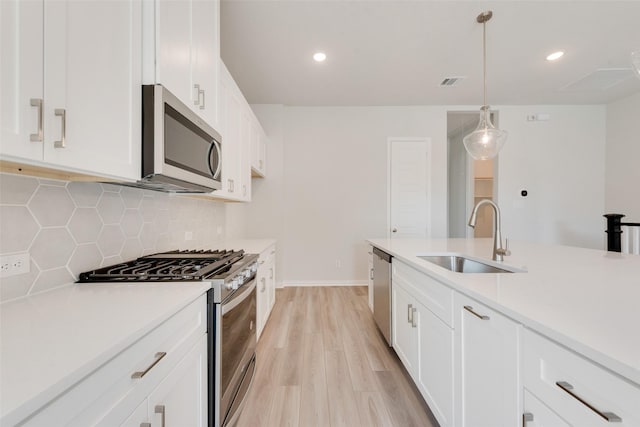 4301 Ruth Rd, North Richland Hills, TX 76180 - kitchen with light wood finished floors, stainless steel appliances, a sink, tasteful backsplash, and visible vents