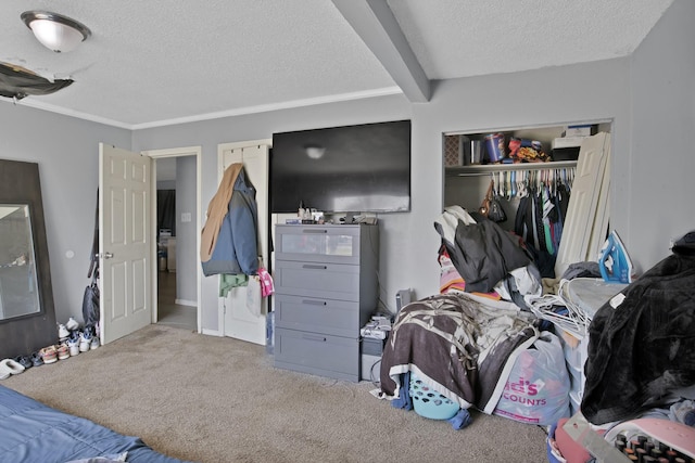 bedroom with a closet, beam ceiling, a textured ceiling, and carpet flooring