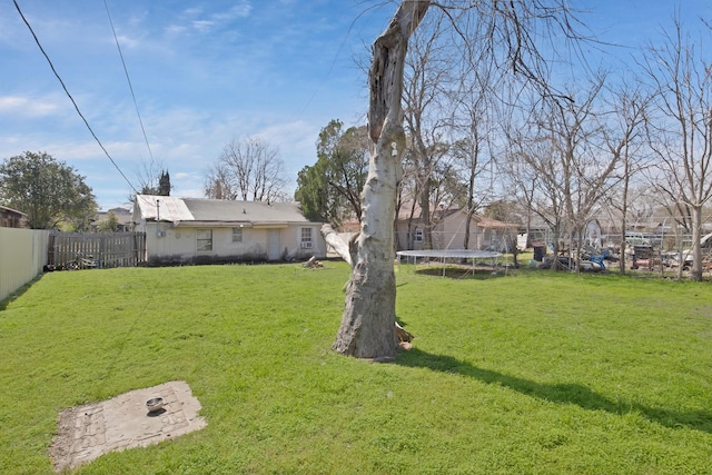 view of yard with a trampoline and a fenced backyard