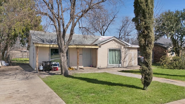 view of front of home with stucco siding and a front lawn