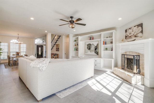 living area featuring light tile patterned floors, stairs, recessed lighting, and a fireplace