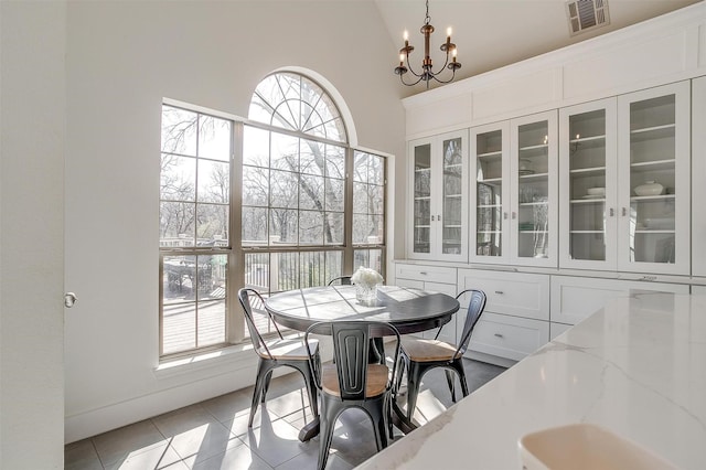 dining space featuring a chandelier, visible vents, a healthy amount of sunlight, and light tile patterned floors