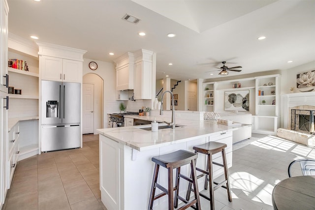 kitchen featuring visible vents, ceiling fan, a sink, white cabinets, and appliances with stainless steel finishes