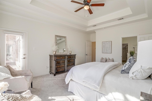 bedroom featuring light carpet, visible vents, and a raised ceiling