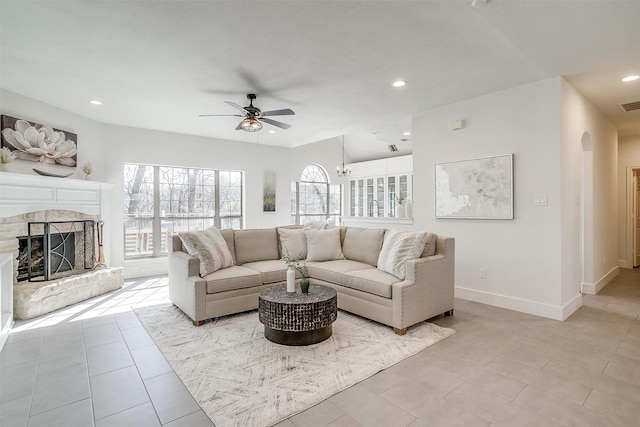 living room featuring a stone fireplace, recessed lighting, baseboards, and a ceiling fan