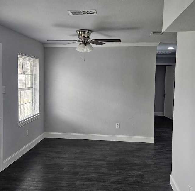 spare room with dark wood-style floors, visible vents, and ceiling fan