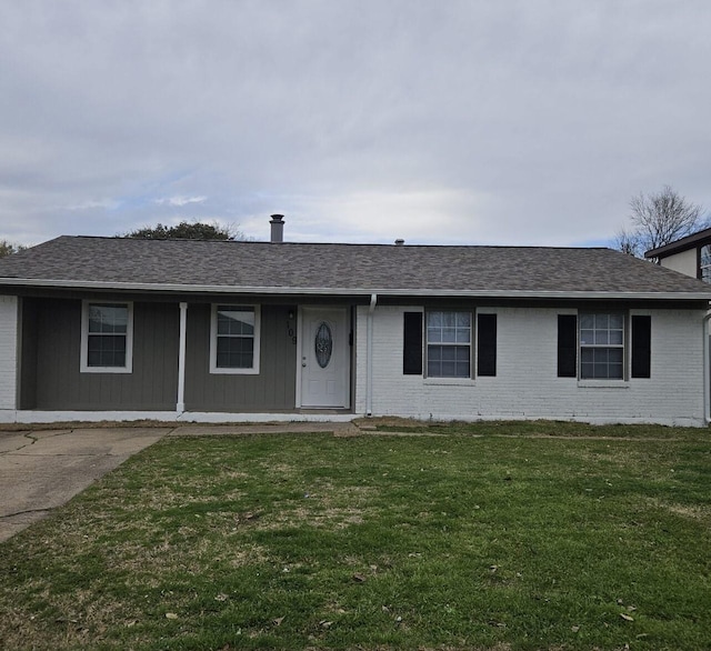 ranch-style house featuring brick siding, a front lawn, and roof with shingles