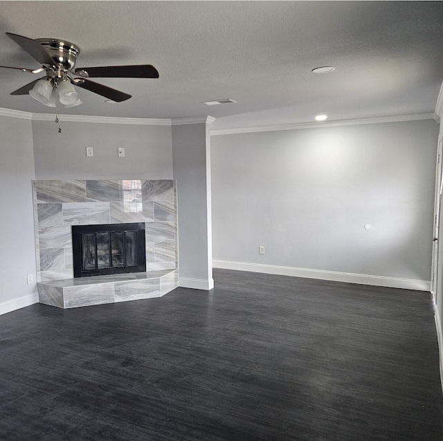 unfurnished living room with baseboards, a tiled fireplace, ornamental molding, wood finished floors, and a textured ceiling