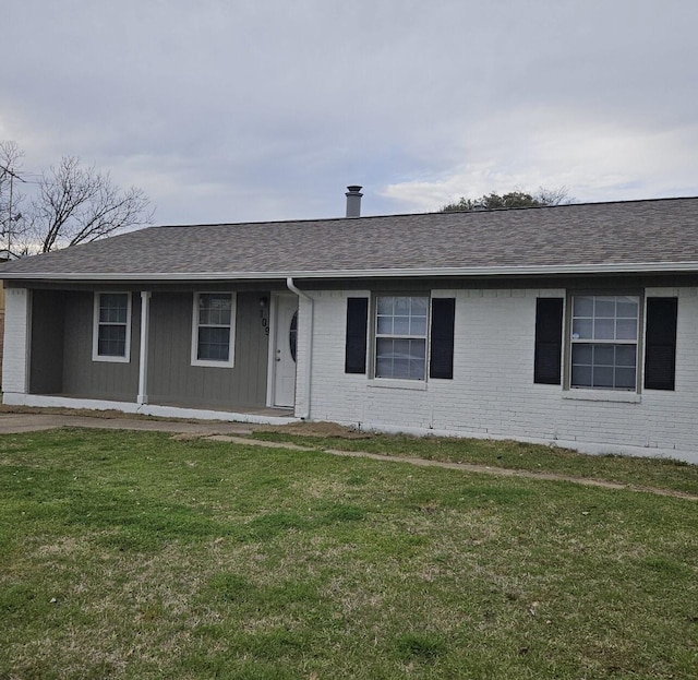 single story home with a front lawn, brick siding, and a shingled roof