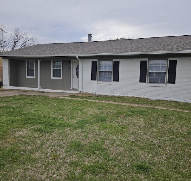 ranch-style home with brick siding, a shingled roof, and a front yard