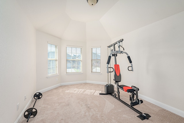 workout area featuring baseboards, lofted ceiling, and carpet flooring