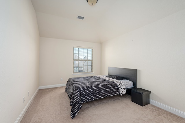 bedroom with vaulted ceiling, visible vents, baseboards, and carpet floors