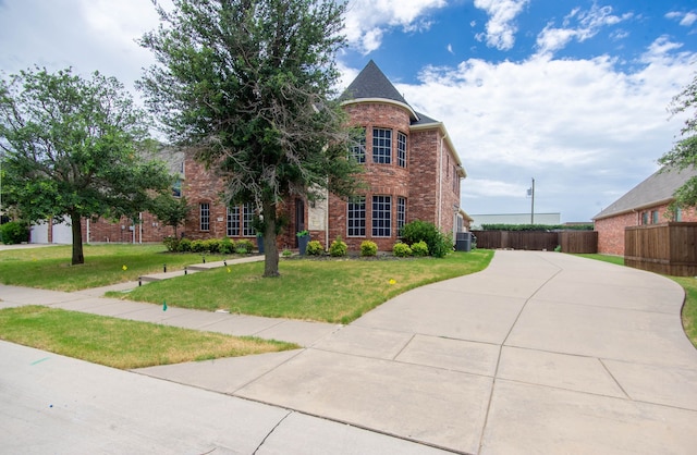 view of front of home featuring brick siding, concrete driveway, a front yard, and fence