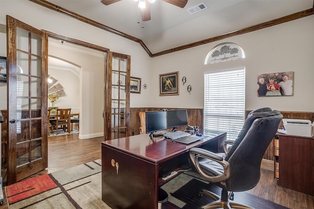 office featuring visible vents, crown molding, wainscoting, wood finished floors, and a ceiling fan