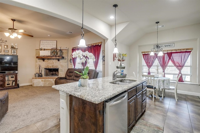 kitchen with visible vents, a sink, stainless steel dishwasher, a fireplace, and light colored carpet