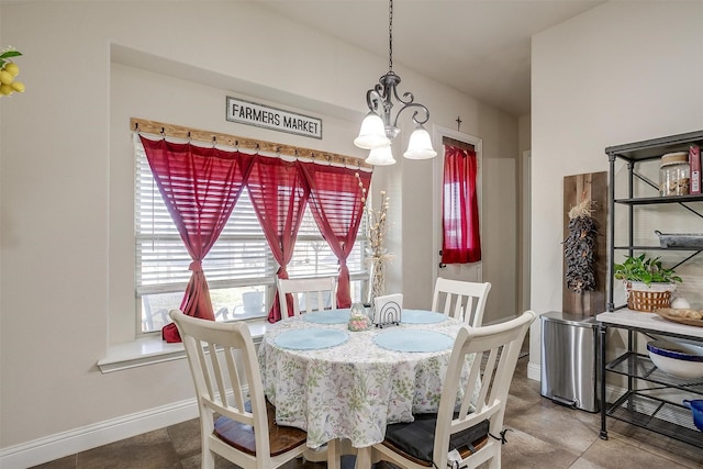 dining space featuring baseboards and a chandelier