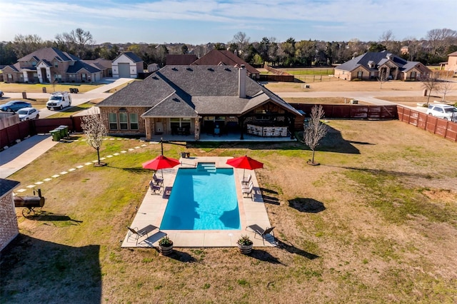 view of swimming pool with a yard, a patio, a residential view, and a fenced backyard