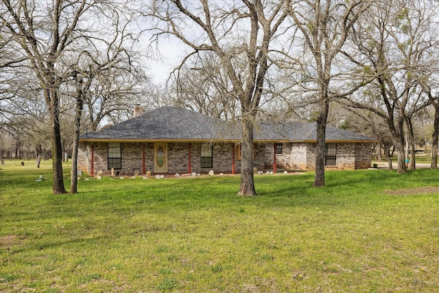 ranch-style home with a front yard, brick siding, and a shingled roof