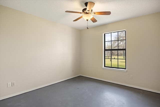 unfurnished room featuring a textured ceiling, a ceiling fan, baseboards, and finished concrete floors