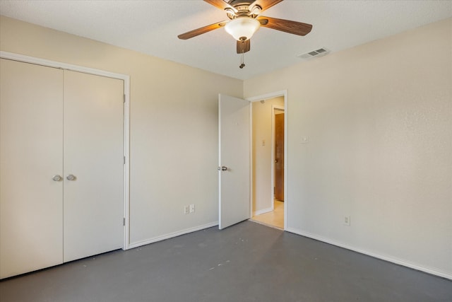 unfurnished bedroom with visible vents, baseboards, finished concrete floors, and a ceiling fan