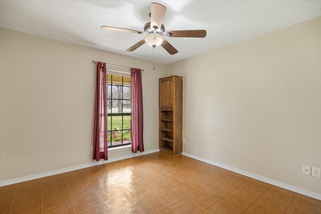 unfurnished room featuring a textured ceiling, baseboards, and ceiling fan