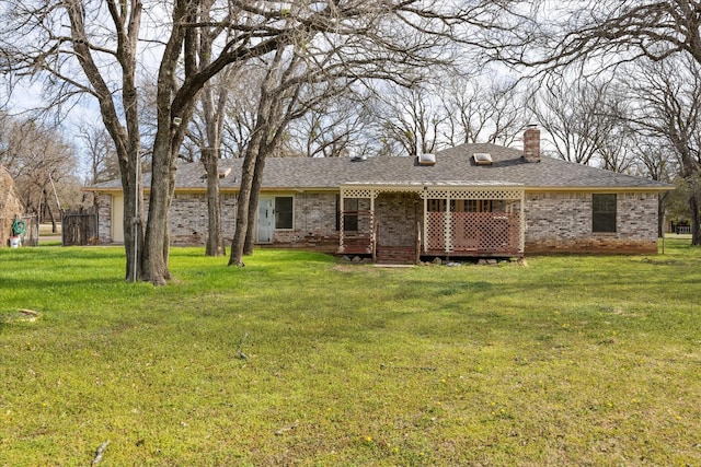 back of house with brick siding, a chimney, and a yard