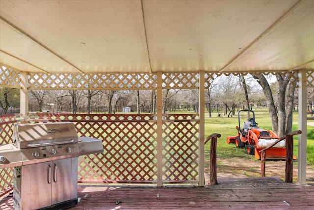 wooden deck with a lawn and a grill