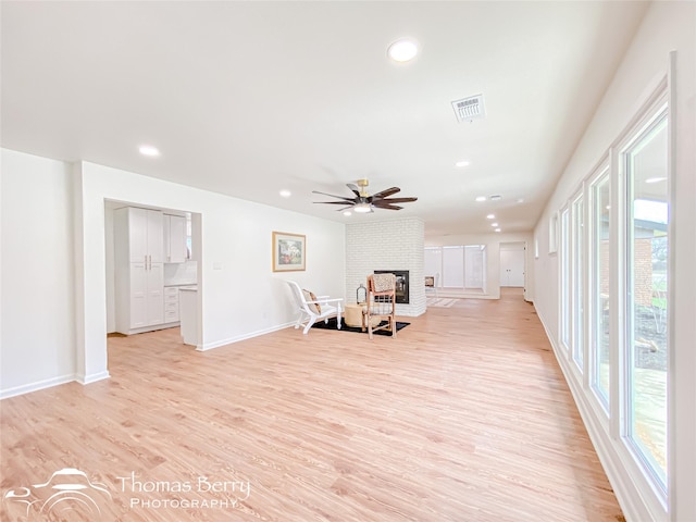 living area featuring light wood-type flooring, visible vents, a ceiling fan, recessed lighting, and a fireplace