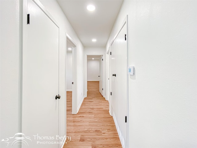 hall featuring recessed lighting, baseboards, and light wood-style flooring