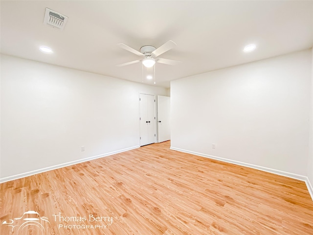 unfurnished room featuring baseboards, light wood-style floors, visible vents, and ceiling fan