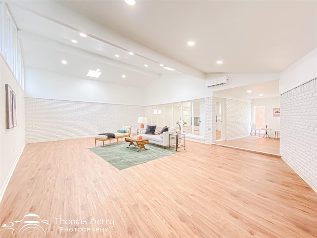 unfurnished room featuring brick wall, vaulted ceiling with beams, a wall mounted air conditioner, recessed lighting, and light wood-style flooring