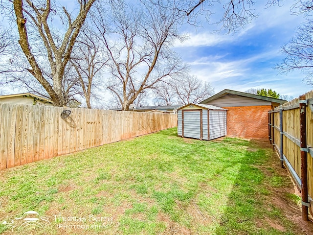 view of yard with an outbuilding, a fenced backyard, and a shed