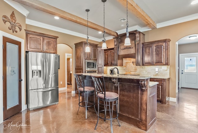 kitchen featuring arched walkways, visible vents, appliances with stainless steel finishes, and tasteful backsplash