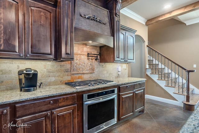 kitchen featuring custom range hood, backsplash, dark brown cabinetry, appliances with stainless steel finishes, and crown molding