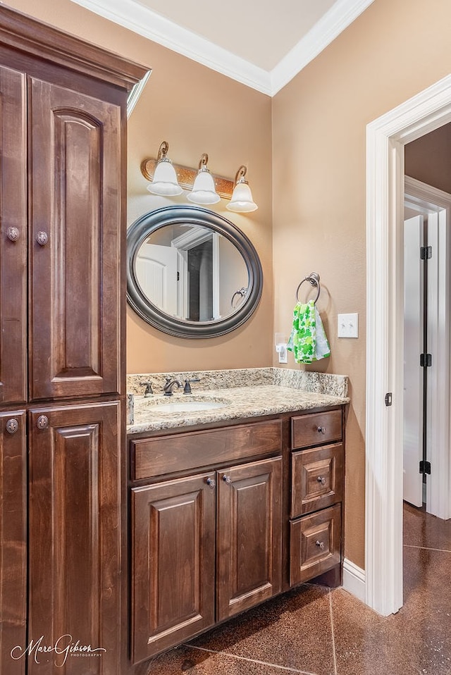 bathroom featuring granite finish floor, vanity, crown molding, and baseboards