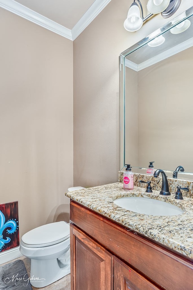 half bath featuring toilet, ornamental molding, and vanity