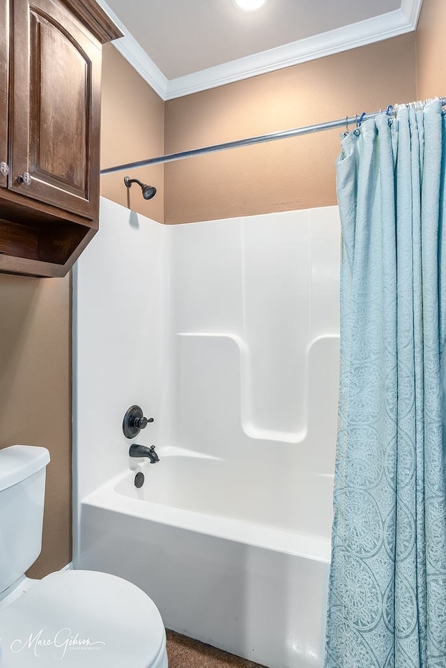 bathroom with toilet, ornamental molding, and shower / tub combo