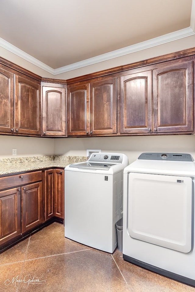 laundry area featuring washer and clothes dryer, cabinet space, and crown molding