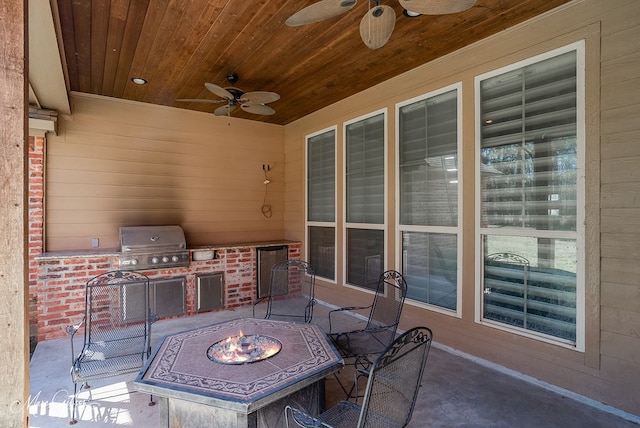 view of patio with grilling area, an outdoor fire pit, exterior kitchen, and a ceiling fan