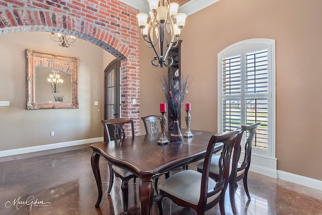 dining space featuring baseboards, arched walkways, and a chandelier