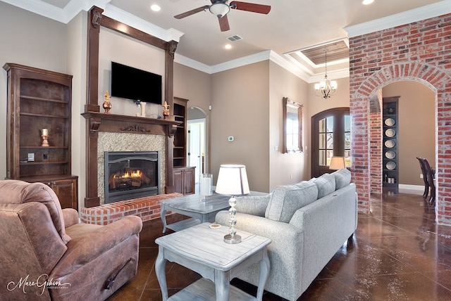 living area with visible vents, a glass covered fireplace, recessed lighting, crown molding, and ceiling fan