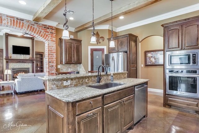 kitchen with visible vents, a kitchen island with sink, a sink, open floor plan, and stainless steel appliances